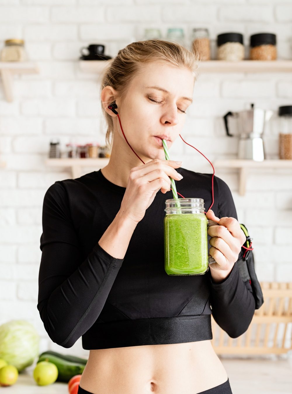 healthy-eating-dieting-concept-young-blond-woman-drinking-green-smoothie-from-mason-jar-at-home-ki.jpg